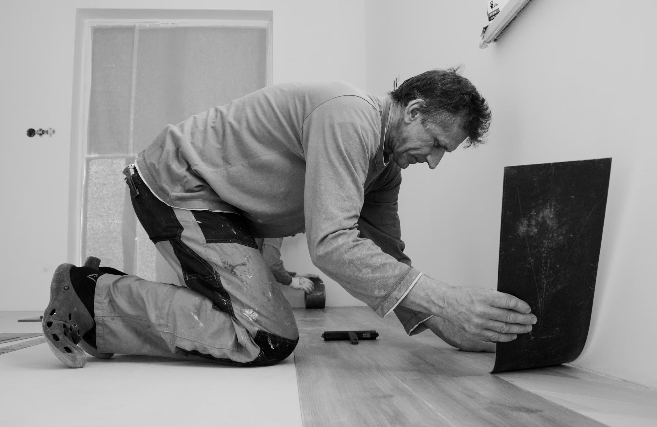 Professional flooring contractor measuring hardwood installation